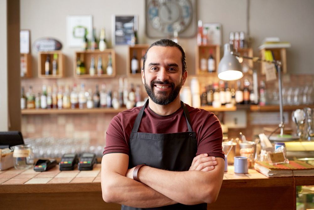 A pub owner smiling as they look at their booking system, which has a VIP guest profile open